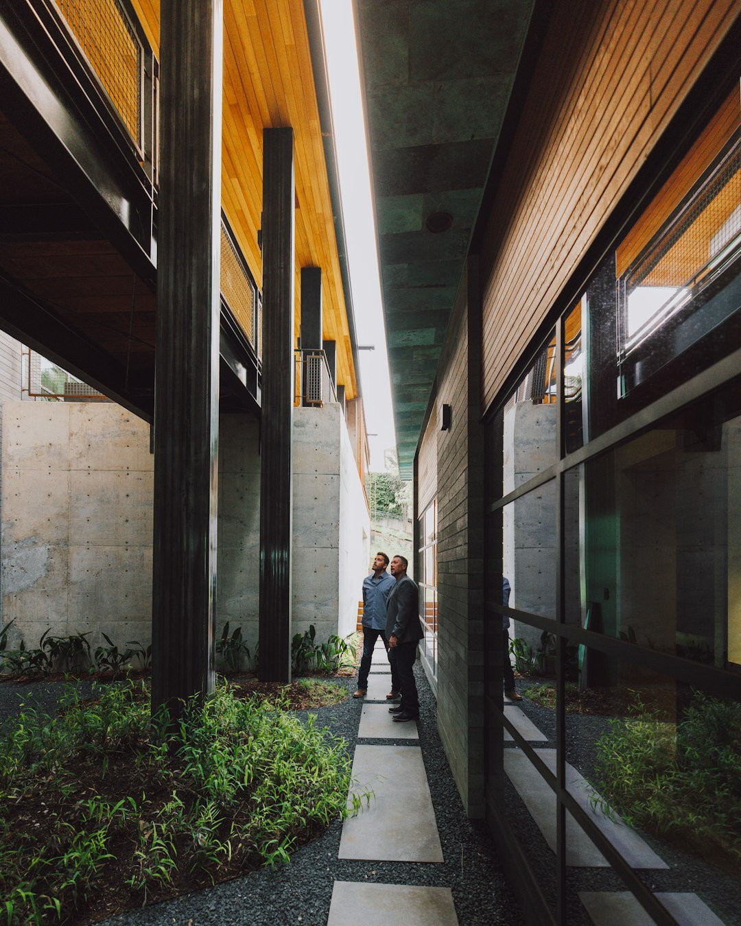 Servicios inmobiliarios Arucas Las Palmas. a-couple-of-people-standing-next-to-each-other-near-a-building-gwzbmpzgpjc